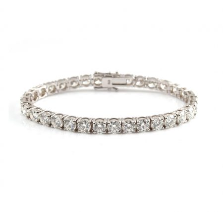 An 18K white gold diamond tennis bracelet featuring 33 claw set round brilliant cut diamonds in four claw baskets and a diamond set clasp. Each diamond is GIA certified.