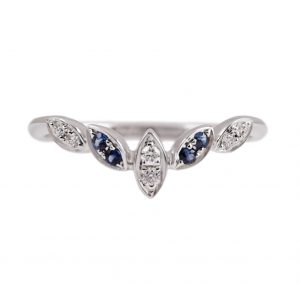 An 18k white gold sapphire and diamond crown ring. The ring is set with four round sapphires which are in a marquise shaped bezel setting and six round brilliant cut diamonds which are set in marquise shape.