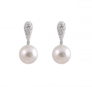 An 18K white gold Autore South sea pearl and pave' diamond earrings. Featuring two white South sea 12mm round pearls suspended from a tear drop pave' style earring. Designed by Autore.